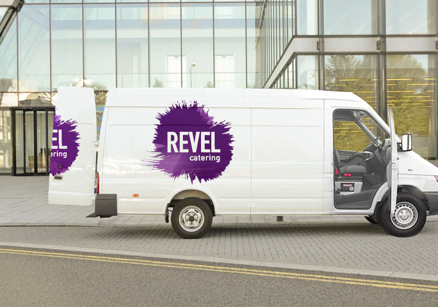 A catering truck outside an office building with the logo on the side and back doors