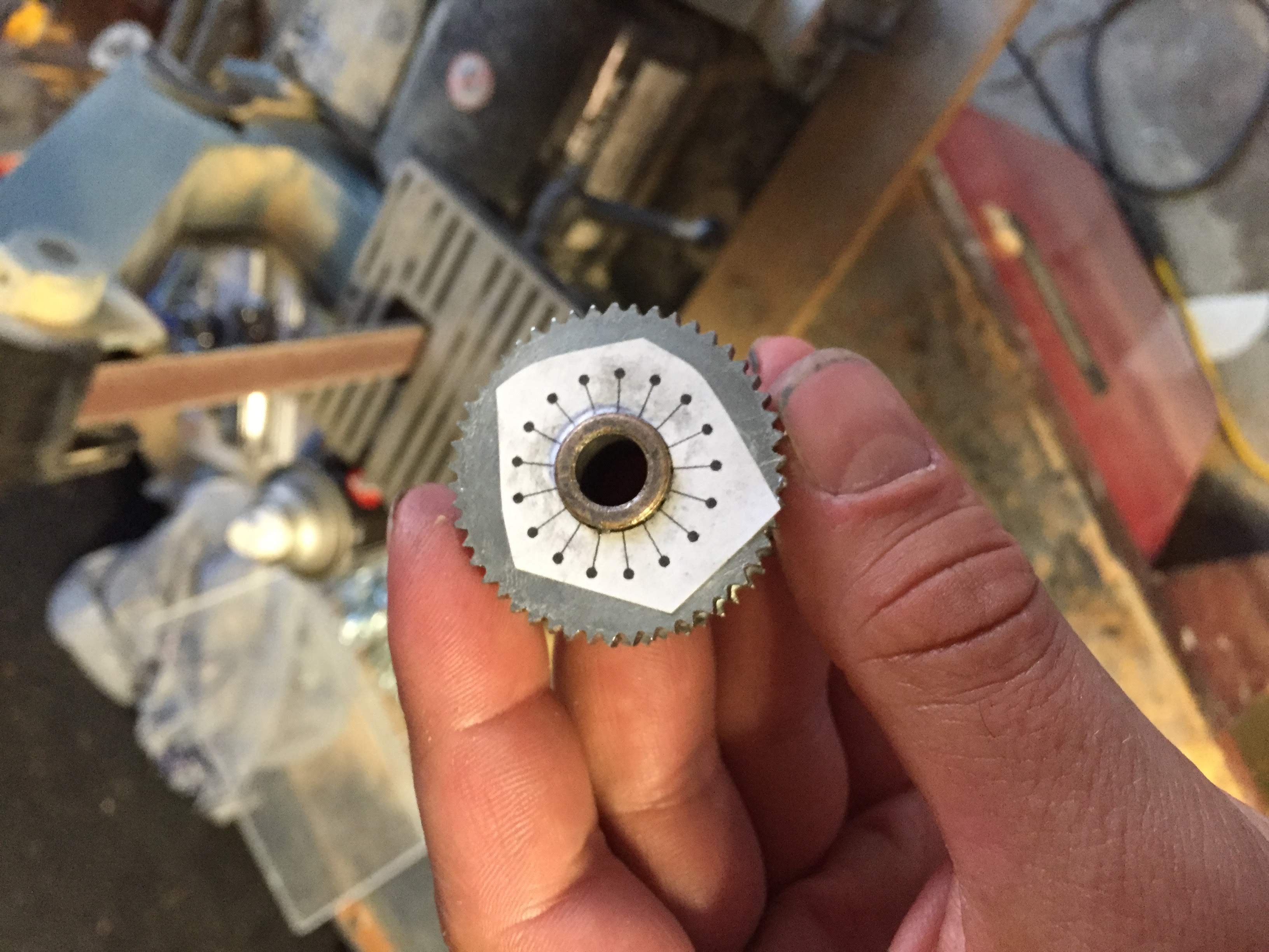 gear with paper template for drilling even spaced hole on the face of it